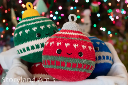Three crocheted Christmas ornaments with faces against a blurred Christmas tree background.