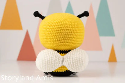 Crocheted bee toy with a colorful geometric background