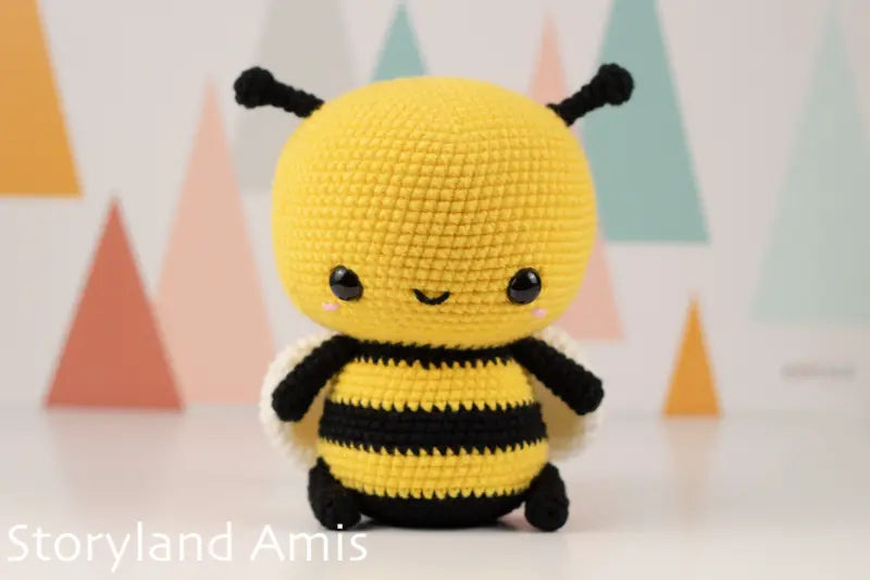 Crocheted bee toy with a colorful geometric background