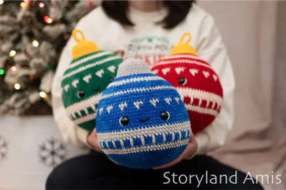 Person holding three crocheted Christmas ornament toys in front of a decorated Christmas tree.