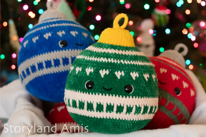 Three crocheted Christmas ornaments in blue, green, and red with a blurred festive background.