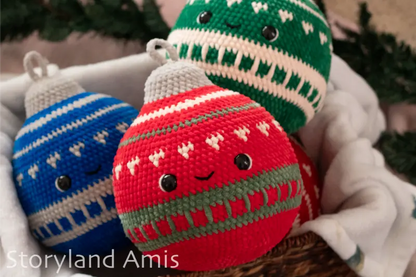 Three crocheted Christmas ornaments in blue, red, and green with 'Storyland Amis' branding.